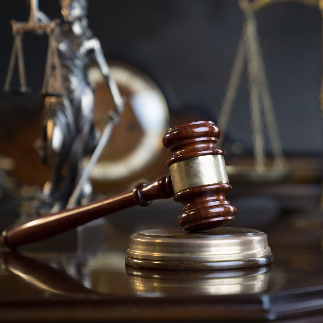 Gavel of  the judge, Themis statue, the clock and the scale on the gray background.